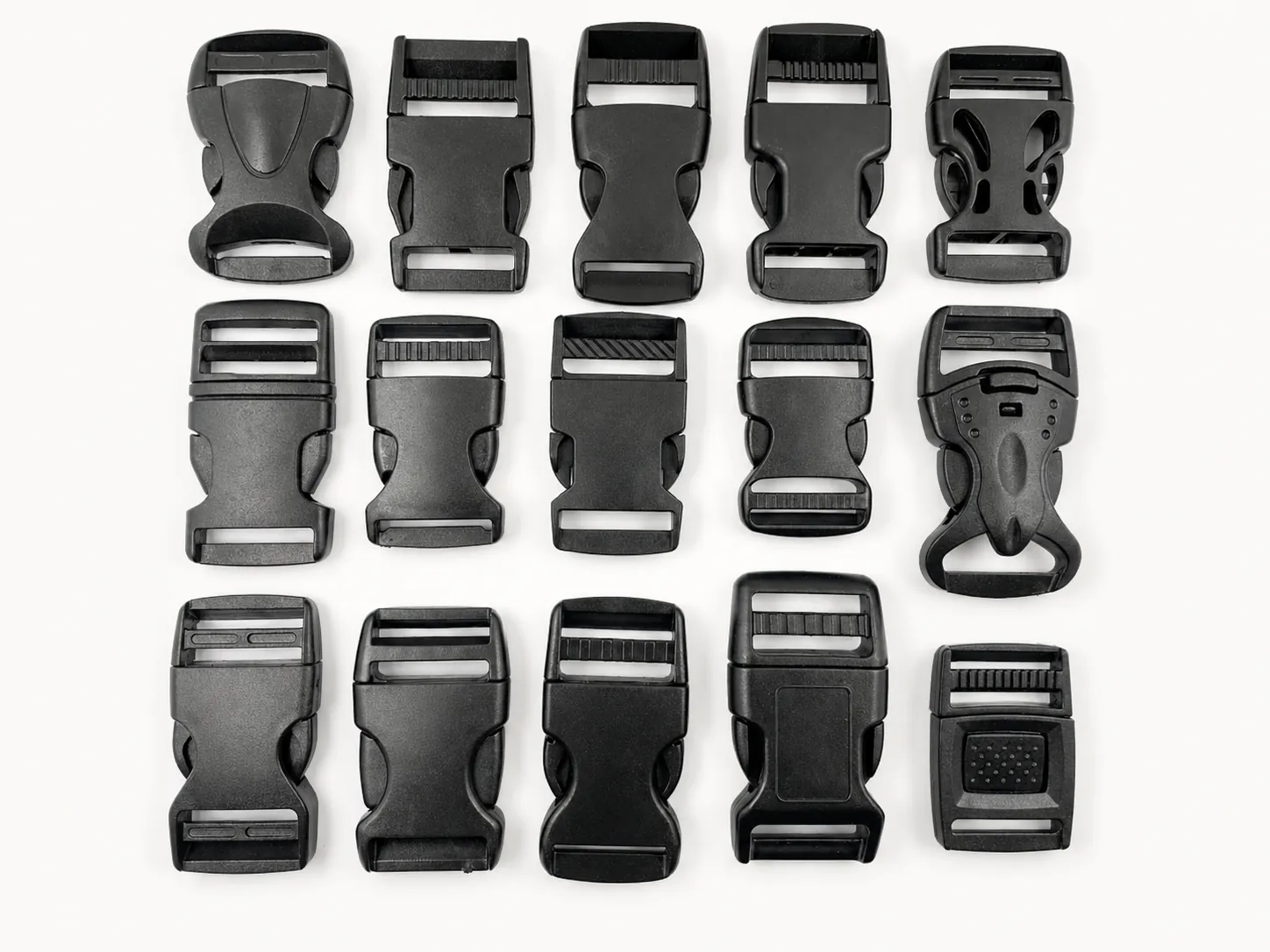 Collection of black plastic quick release buckles arranged on white background