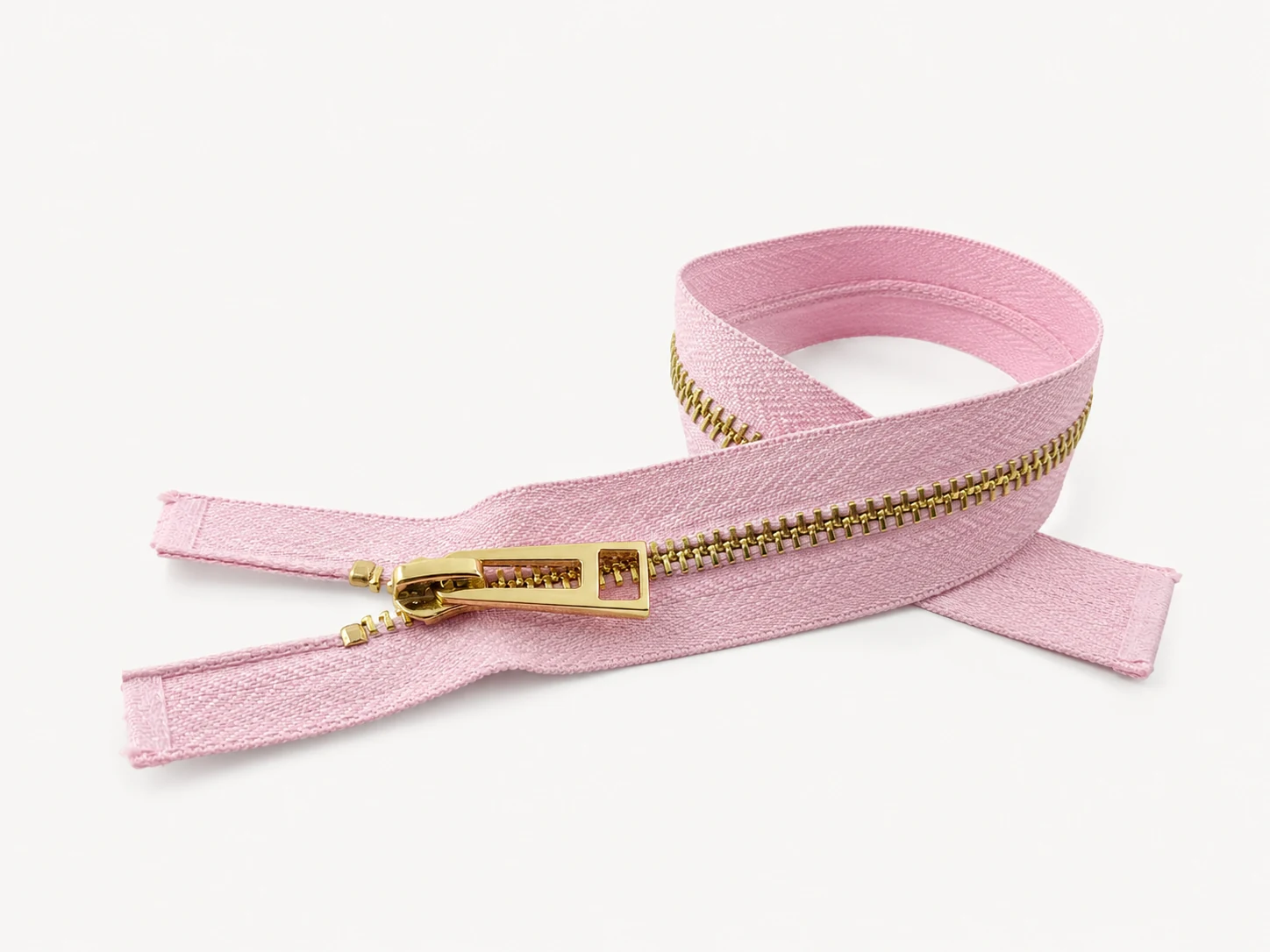 pink zipper with gold metal teeth and gold slider on white background