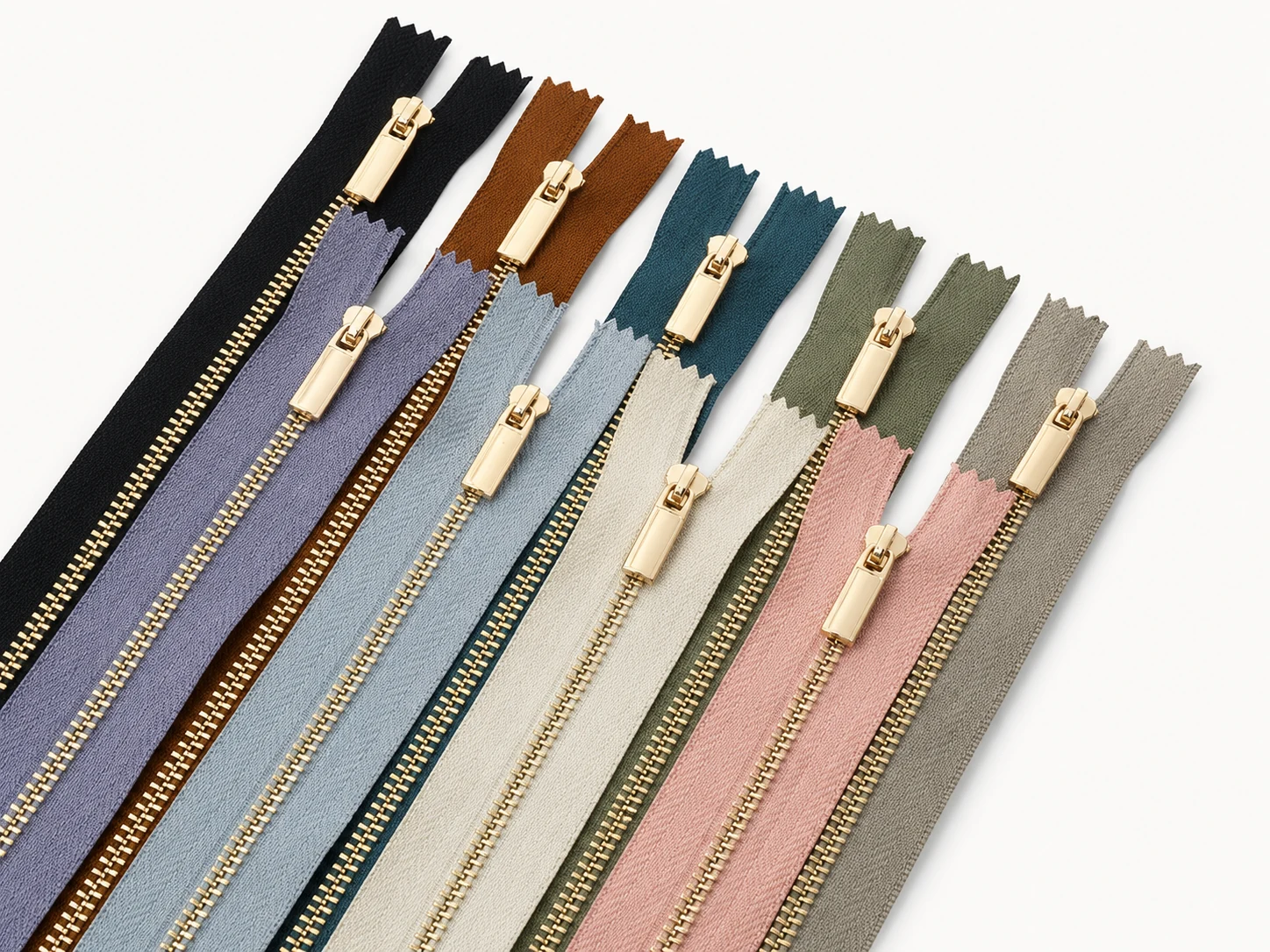 pastel fabric zippers with gold metal teeth arranged in a lineup